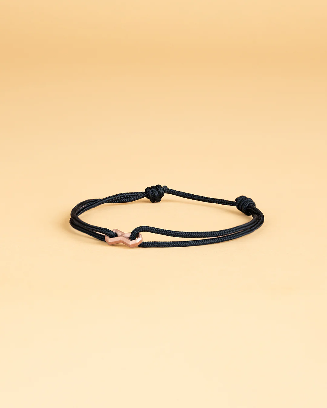 Black nylon bracelet with a bronze-plated infinity sign